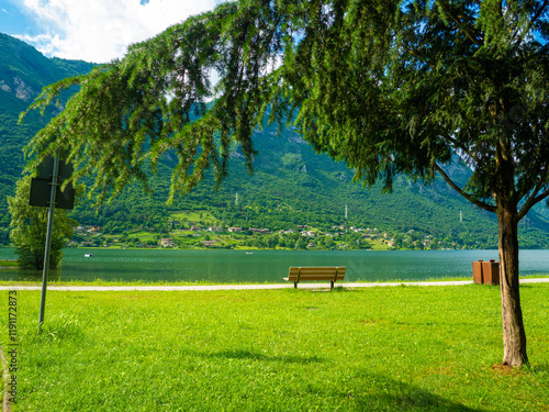 Crone public park with empty benches on Lake Idro, Lombardy, Italy. Empty lakefront with beach of the small Crone village. Tourist resort in Brescia province, Lombardy. photo