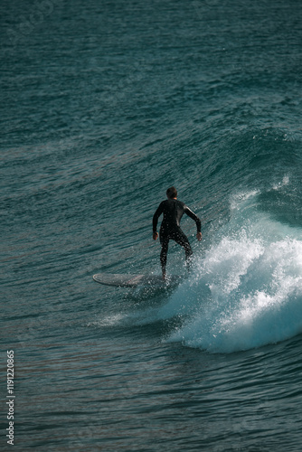 Surfing big waves on a blue sea