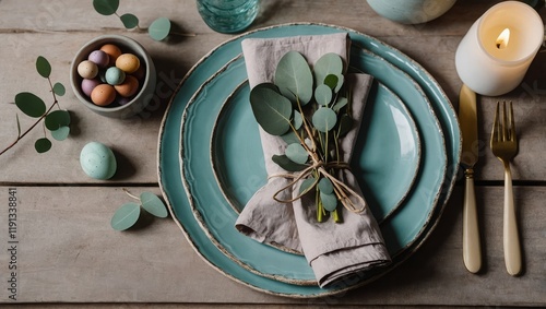 Plates with napkin, cutlery and eucalyptus branch on table served for Easter celebration