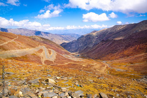 Winding road among the yellow grass, Babusar Pass. Beautiful autumn landscape in Karakoram mountains, Pakistan.  photo