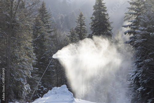 Obraz na płótnie Snow making in a mountain resort. Beautiful view with snow cannons powered on to create snow from water and to keep the slopes available for tourists. w salonie