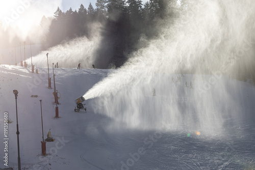 Obraz na płótnie Snow making in a mountain resort. Beautiful view with snow cannons powered on to create snow from water and to keep the slopes available for tourists. w salonie