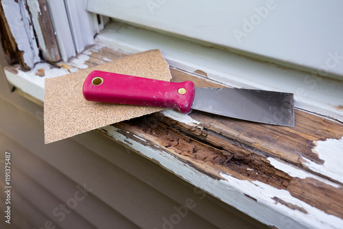 Foto Repairing rotten wood window sill with a putty knife and sandpaper