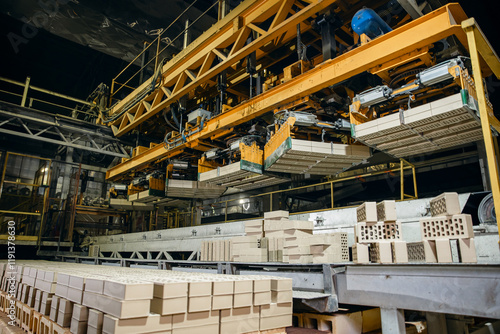 Fotografie Automated robot manipulator for gripping and transferring bricks to conveyor bel