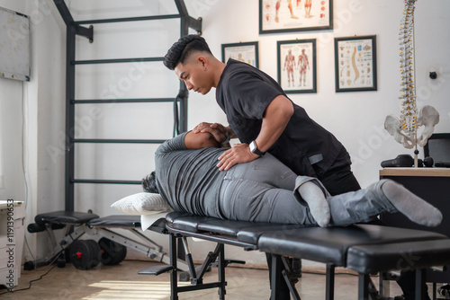 Chiropractic Treatment: A skilled chiropractor provides treatment to a patient on a massage table in a professional office setting, demonstrating a commitment to holistic health and pain management. photo