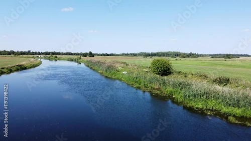  View of a Beautiful  River at Sunset Surrounded by Green Fields Drone Aerial 4K Slow Motion