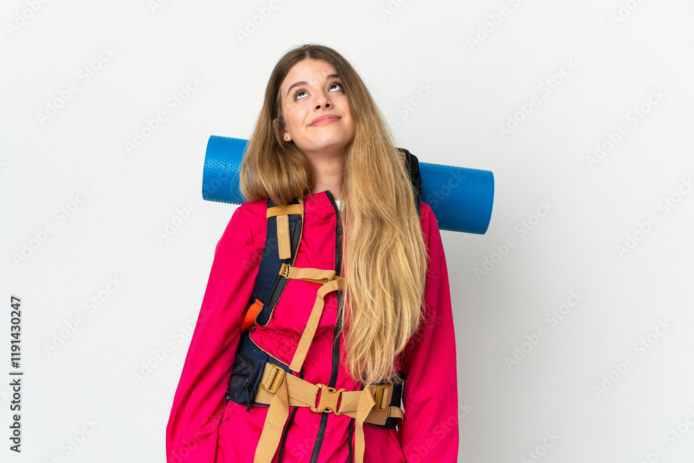 Young mountaineer woman with a big backpack over isolated background and looking up Young mountaineer woman with a big backpack over isolated background and looking up