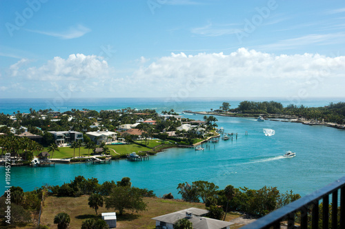 View from Lighthouse Overlooking Jupiter Inlet, Florida. Sunny day blue sky and white clouds. Boats in water with small wakes. Scenic intercoastal waterway.