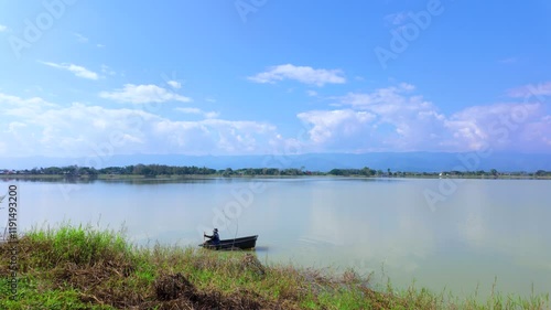 lake and blue sky Person Rowing a Boat on a Serene Lake