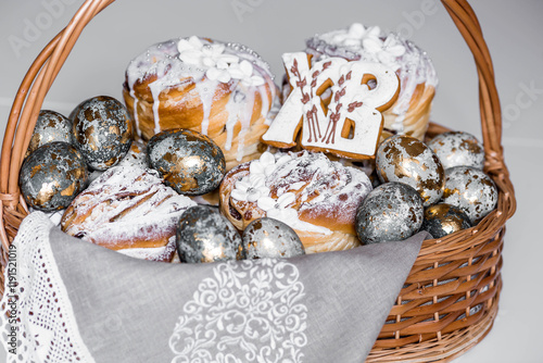 Banner for Orthodox Easter. Easter eggs with gold, Easter cakes and gingerbread in the shape of the letters XB in a woven basket made of vines. photo