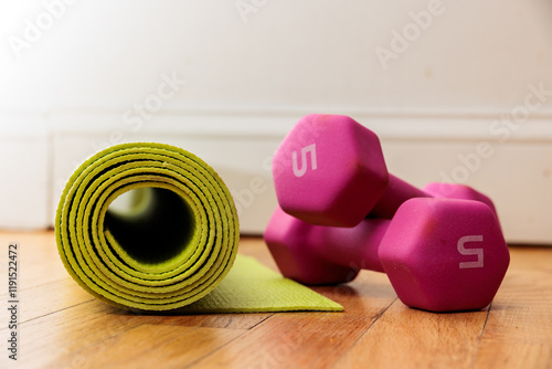 Fitness essentials: yoga mat and dumbbells ready for a workout.