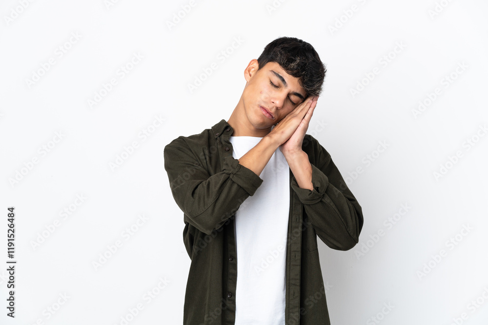 Young man over isolated white background making sleep gesture in dorable expression Young man over isolated white background making sleep gesture in dorable expression