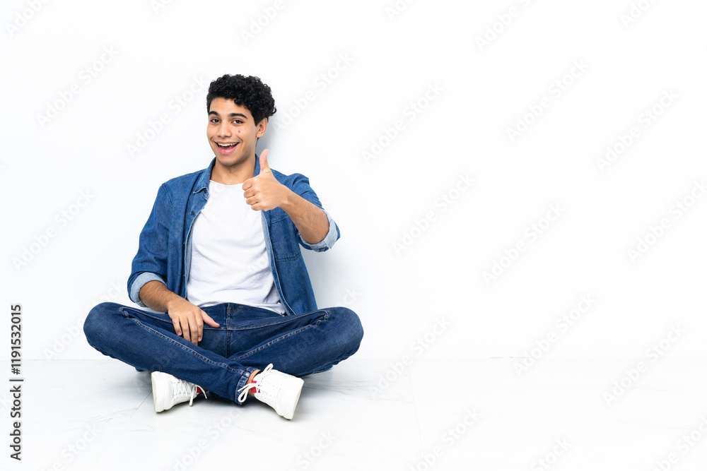 Venezuelan man sitting on the floor with thumbs up because something good has happened Venezuelan man sitting on the floor with thumbs up because something good has happened