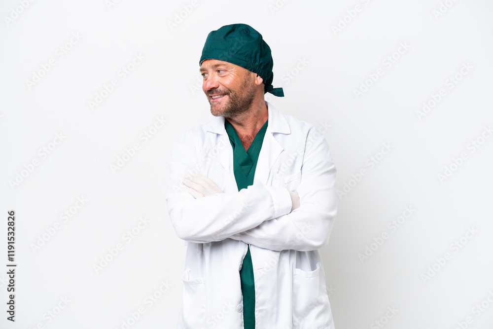 Middle age surgeon in green uniform isolated on white background looking side Middle age surgeon in green uniform isolated on white background looking side