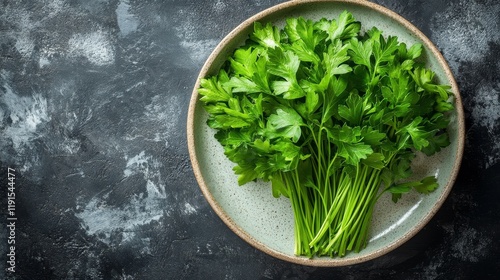 Fresh parsley displayed on a rustic plate against a dark textured background ...