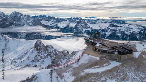 Stazione a Monte - Funivia Sass Pordoi in winter offers an unforgettable experience in the heart of the Dolomites. Captured by drone, the scene showcases the snowy summit station Passo Pordoi below