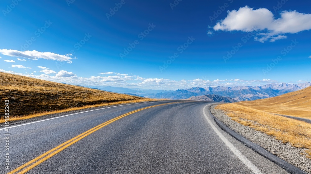 Winding road with mountains in background under clear blue sky Winding road with mountains in background under clear blue sky