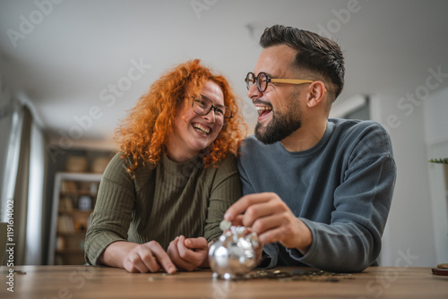 Adult happy couple save money coins in the piggy bank at home