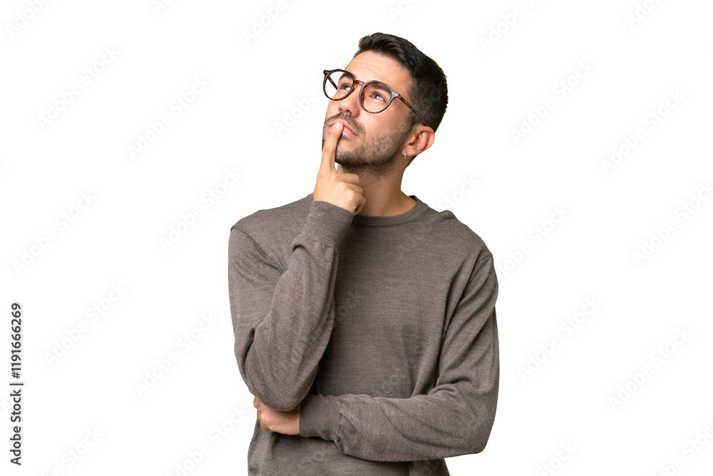 Fototapeta premium Young handsome caucasian man over isolated background having doubts while looking up
