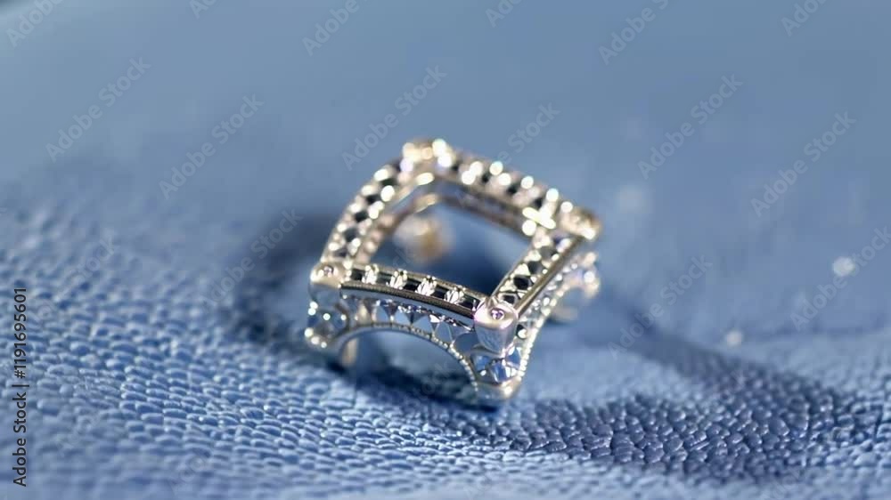 Close-up of a stunning diamond ring with a halo setting, resting elegantly on a blue surface, showcasing its brilliant sparkle and intricate design. Close-up of a stunning diamond ring with a halo setting, resting elegantly on a blue surface, showcasing its brilliant sparkle and intricate design.