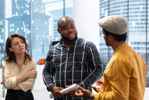 Entrepreneurs sharing their workspace vision with the broker, evaluating architectural blueprints for a new office space in high class urban building. Potential investment in property. photo