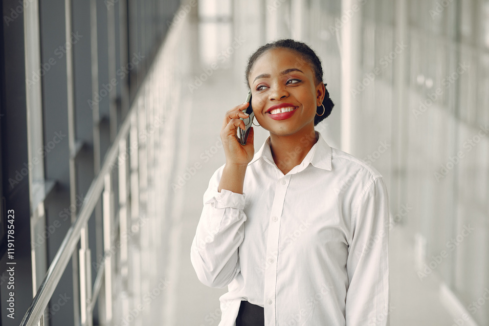 Black woman standing in the office with a laptop Black woman standing in the office with a laptop
