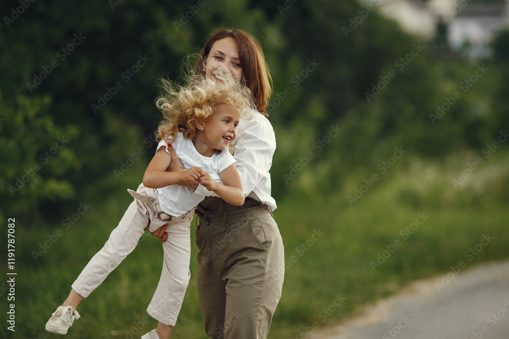 Fototapeta premium Mother with daughter playing in a summer field