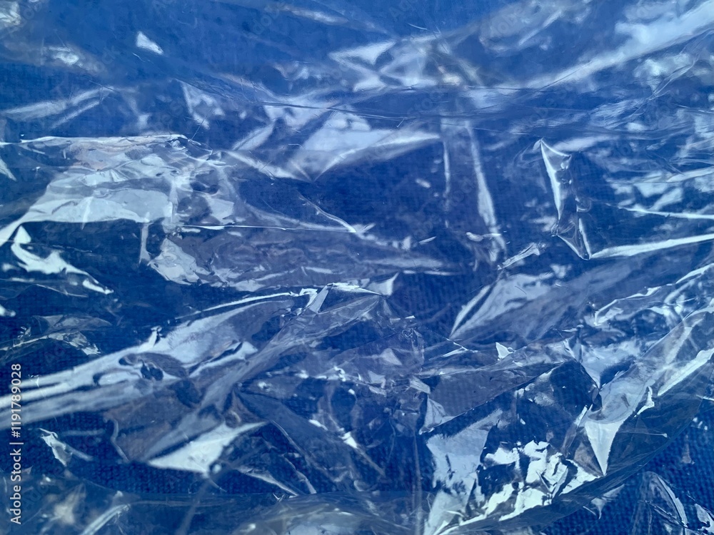 Clear crumpled reflective plastic on blue ground Clear crumpled reflective plastic on blue ground