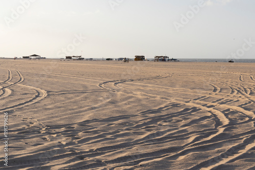 A deserted beach emphasizing the unique textures of the sand under a sunny sky in São Miguel do Gostoso, Rio Grande do Norte, Brazil—a tranquil coastal scene highlighting natural beauty. photo