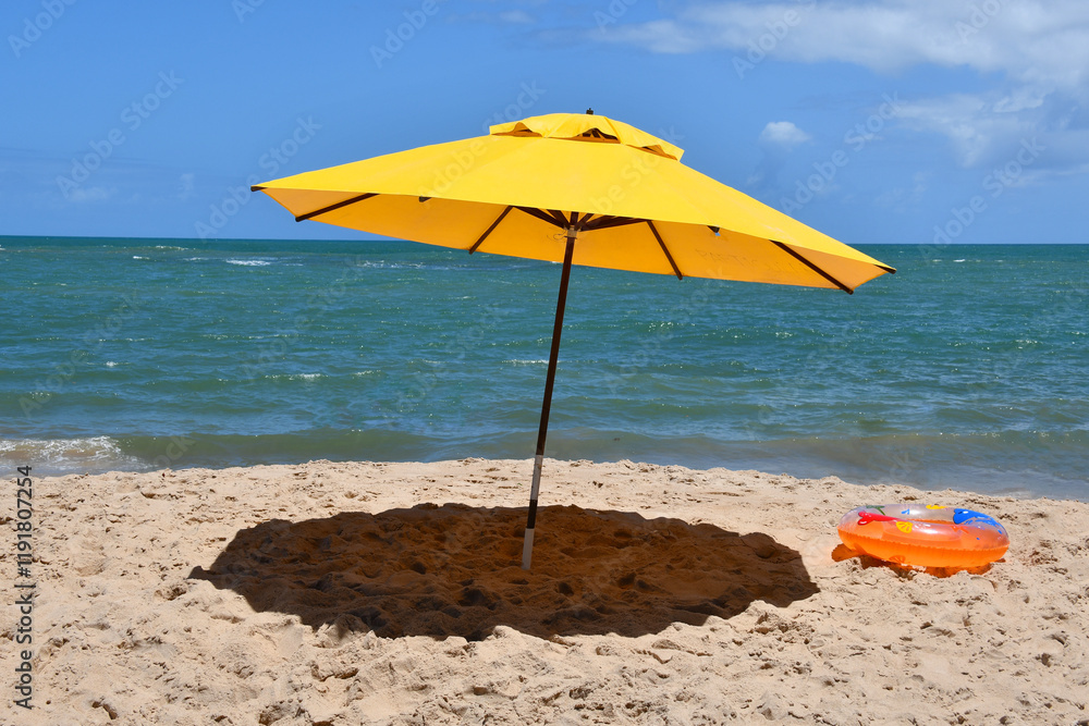 Yellow umbrella on the beach with the sea in the background. Itacimirim, Bahia-Brazil Yellow umbrella on the beach with the sea in the background. Itacimirim, Bahia-Brazil