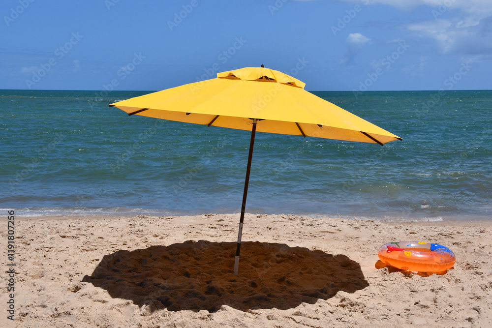 Yellow umbrella on the beach with the sea in the background. Itacimirim, Bahia-Brazil Yellow umbrella on the beach with the sea in the background. Itacimirim, Bahia-Brazil