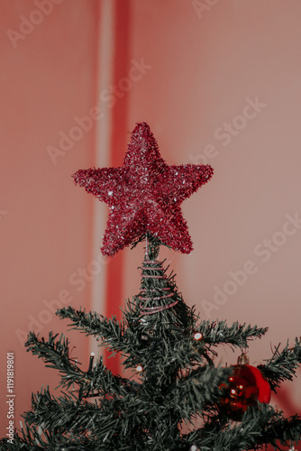 Pink decorative star for the top of the Christmas tree, on a pink background.