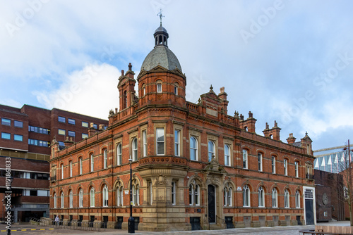 Beautiful Victorian-era building with intricate red-brick and stonework details in Manchester, UK. This architectural gem features arched windows, a central dome photo