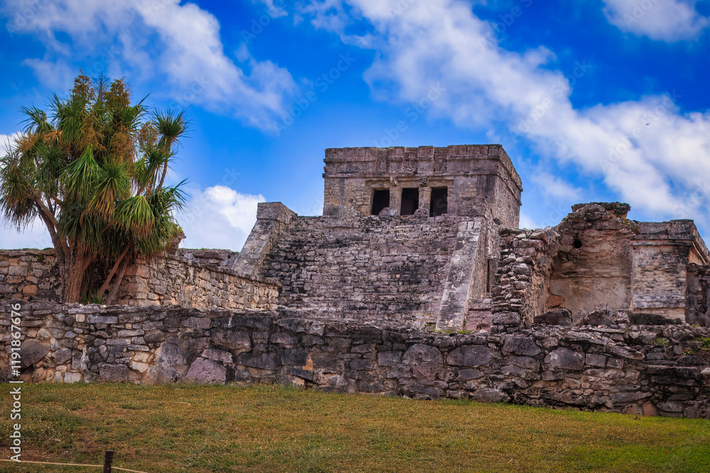 A large Tulum stone building with a tree in front of it A large Tulum stone building with a tree in front of it