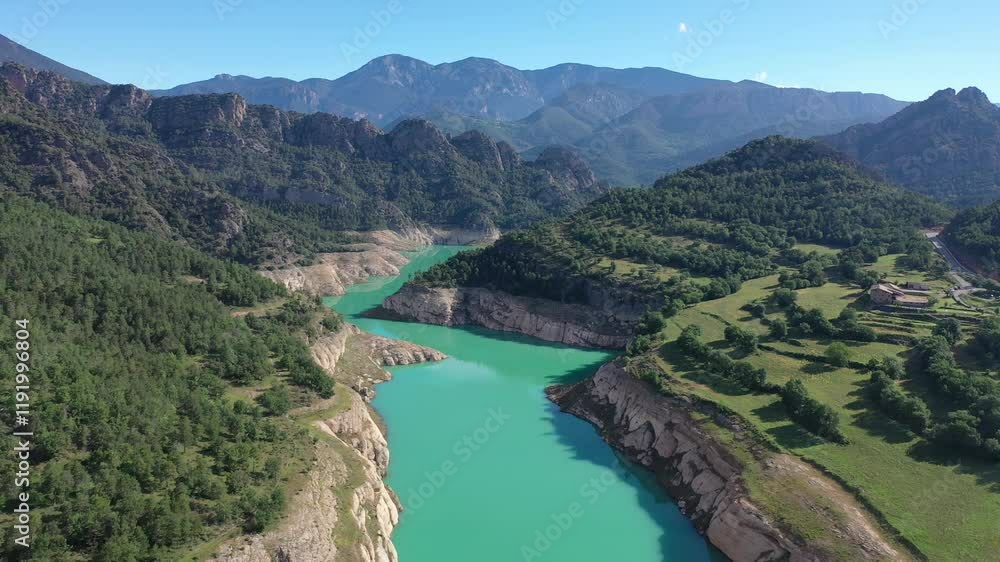 Turquoise Llosa del Cavall Reservoir on Cardener River winding through picturesque mountainous landscape in Catalonia, Spain, surrounded by lush greenery and rocky cliffs under clear blue sky Turquoise Llosa del Cavall Reservoir on Cardener River winding through picturesque mountainous landscape in Catalonia, Spain, surrounded by lush greenery and rocky cliffs under clear blue sky