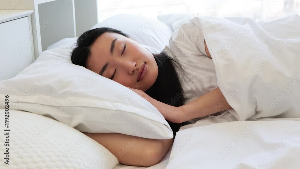 Asian woman asleep in cozy bed, surrounded by white linens, capturing serenity and tranquility of restful sleep. Perfect depiction of relaxation and peaceful atmosphere. Asian woman asleep in cozy bed, surrounded by white linens, capturing serenity and tranquility of restful sleep. Perfect depiction of relaxation and peaceful atmosphere.