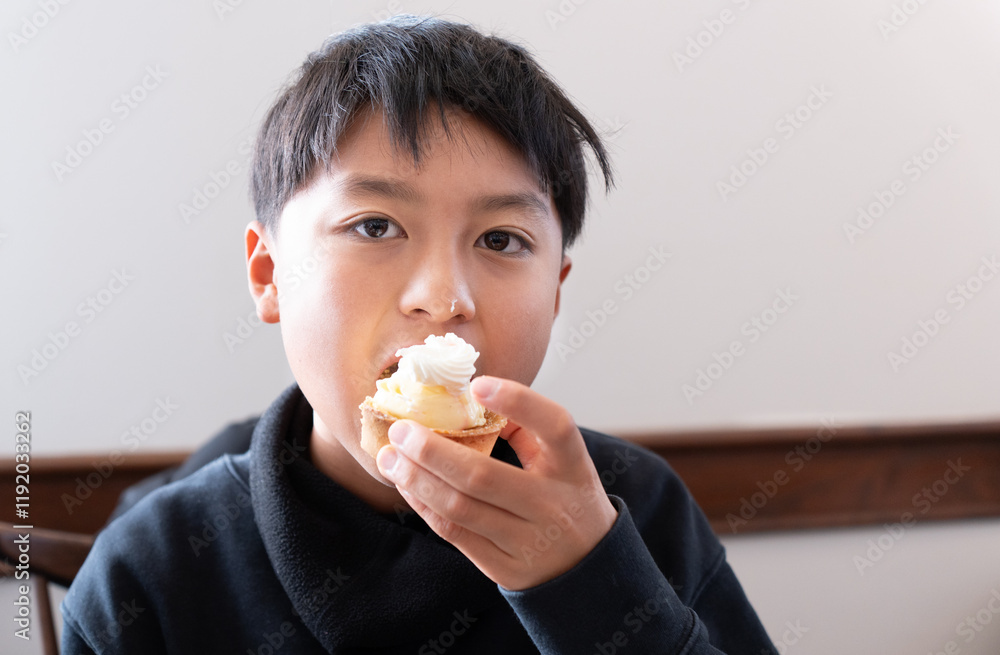 食後のデザートにケーキを食べている日本人の男の子