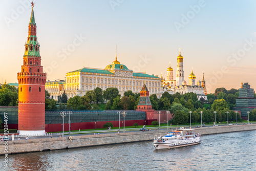 View of Kremlin with Vodovzvodnaya tower, Grand Kremlin Palace from repaired Bolshoy Kamenny Bridge in Moscow city on sunny summer day. Cruise ship sails on the Moscow river