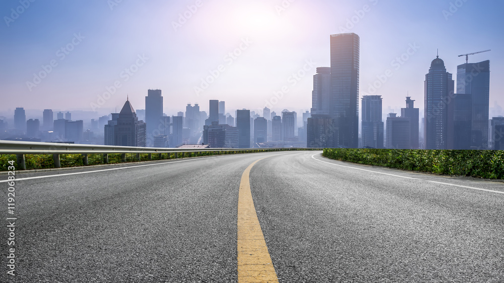 Smooth Curving Road Leading to a Modern City Skyline at Dawn Smooth Curving Road Leading to a Modern City Skyline at Dawn