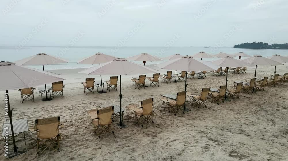 Rows of umbrellas set with chair and table along the beach Rows of umbrellas set with chair and table along the beach