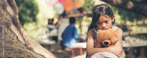Fotografía Banner Sad girl hug teddy bear sit sadness alone in green park