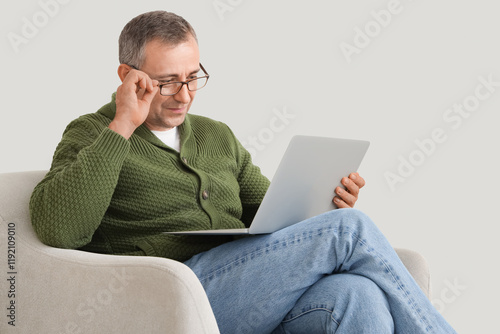 Old man with laptop sitting...