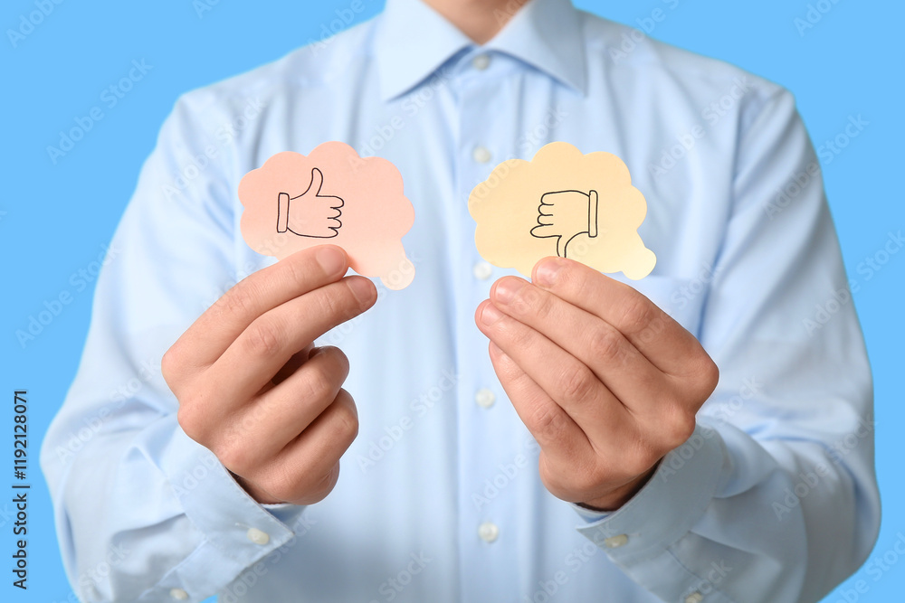 Man with rating thumbs on blue background, closeup. Survey concept