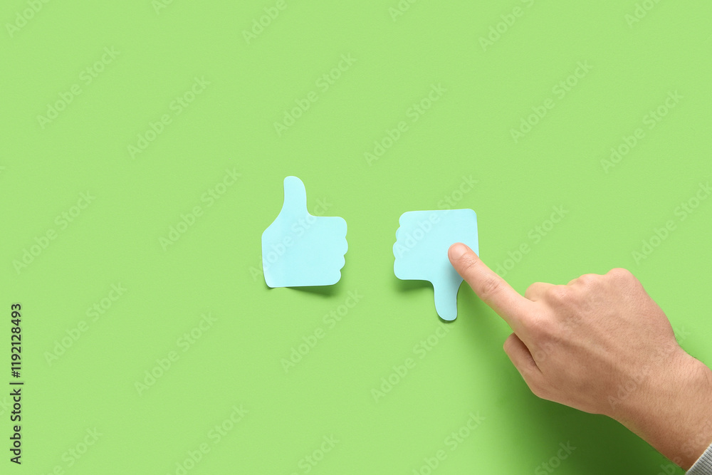 Fototapeta premium Man pointing at rating thumbs on green background. Survey concept