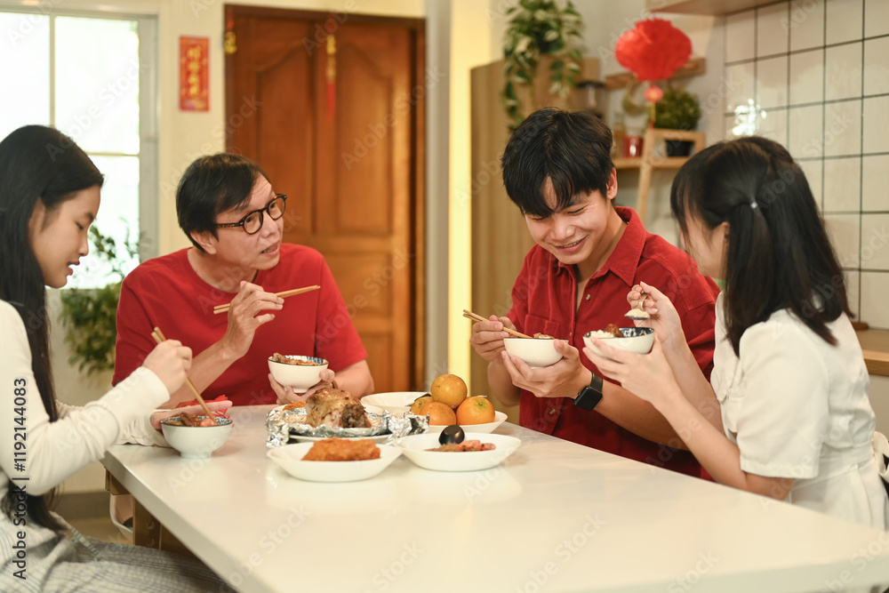 Family gathering for Chinese New Year celebration and enjoying traditional meal together in a festive home Family gathering for Chinese New Year celebration and enjoying traditional meal together in a festive home