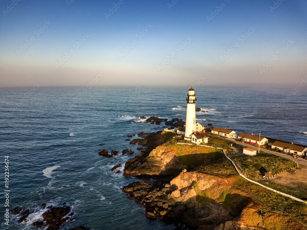 Scenic lighthouse on rocky coastline at sunset Scenic lighthouse on rocky coastline at sunset