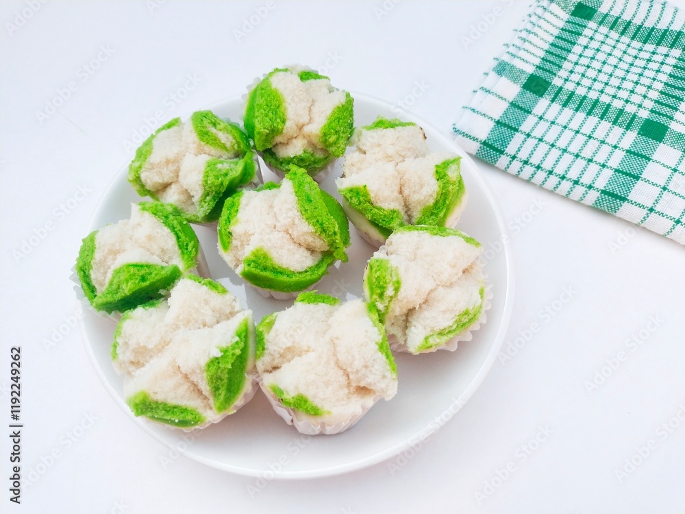 Close-up of steamed sponge cake blooms in a white plate on a white background. High angle view. Close-up of steamed sponge cake blooms in a white plate on a white background. High angle view.