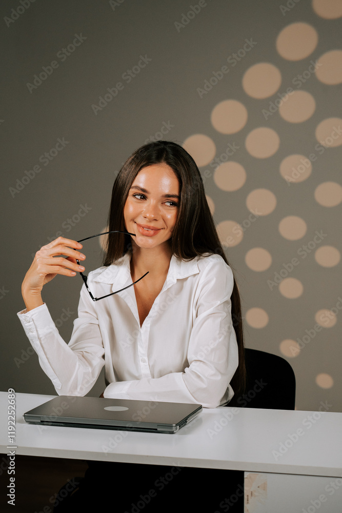 Woman in white shirt thoughtfully working on laptop while considering strategies for online business development Woman in white shirt thoughtfully working on laptop while considering strategies for online business development