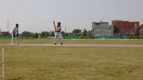 Low view of a batsman hitting a helicopter shot in a cricket match