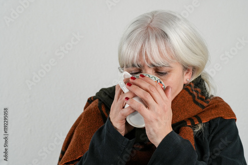 Sie ist erkältet und trinkt darum heissen Tee photo